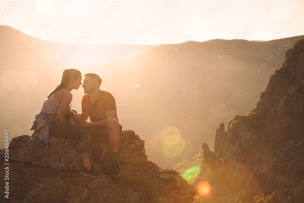 Young couple at mountains on the sunset