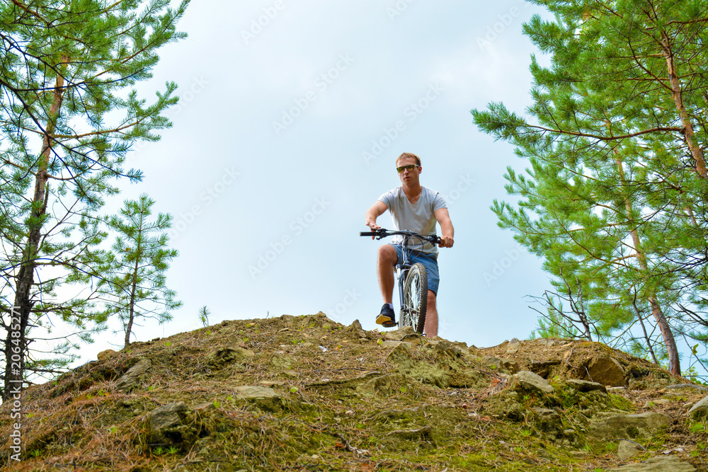 athlete with a mountain bike down the hill.Healthy lifestyle.Walking by bike