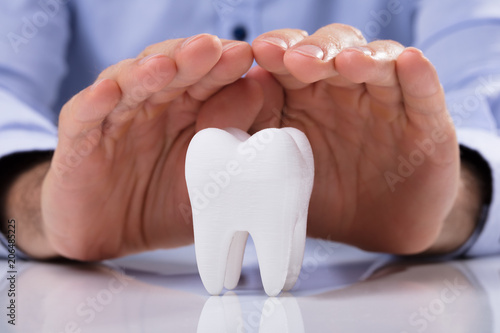 Man's Hand Protecting White Tooth