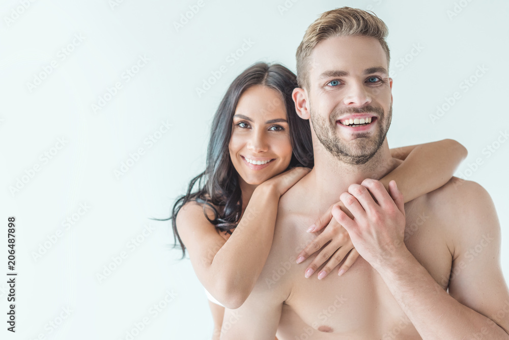 young smiling couple hugging and looking at camera, isolated on white young smiling couple hugging and looking at camera, isolated on white