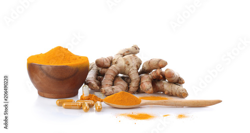 Turmeric , turmeric powder in wooden cup with wooden spoon and turmeric capsules on white background.