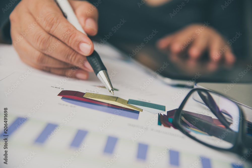 Business people are working on accounts in business analysis with graphs and documentation. Business people are working on accounts in business analysis with graphs and documentation.