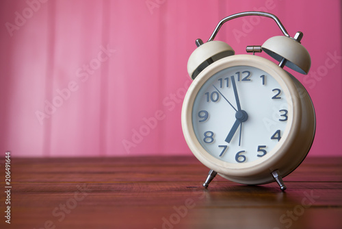  white alarm clock is placed in the pink room.