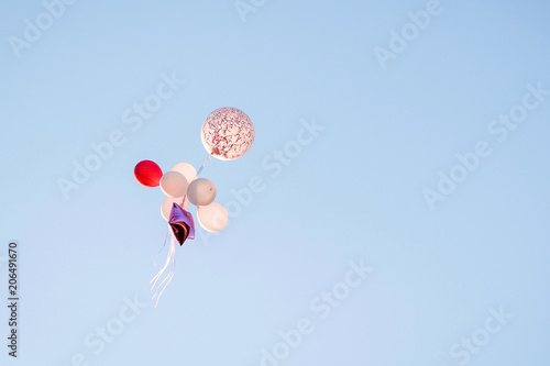 Bunch of trendy colorful balloons in blue sky.