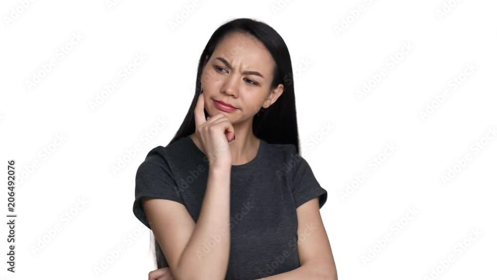 Portrait of serious woman with brown long hair being deep in thoughts and doing pensive gesture while trying to choose best option, over white background. Concept of emotions Portrait of serious woman with brown long hair being deep in thoughts and doing pensive gesture while trying to choose best option, over white background. Concept of emotions