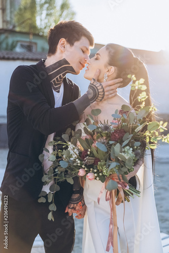 young beautiful bride and groom embracing and kissing on wedding Fototapet