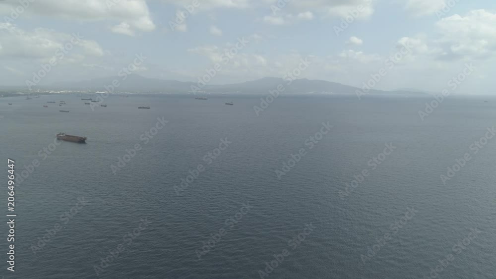 Aerial view cargo and merchant ships in harbor. trading vessels in the bay awaiting loading and unloading at the seaport. Batangas, Philippines. Aerial view cargo and merchant ships in harbor. trading vessels in the bay awaiting loading and unloading at the seaport. Batangas, Philippines.