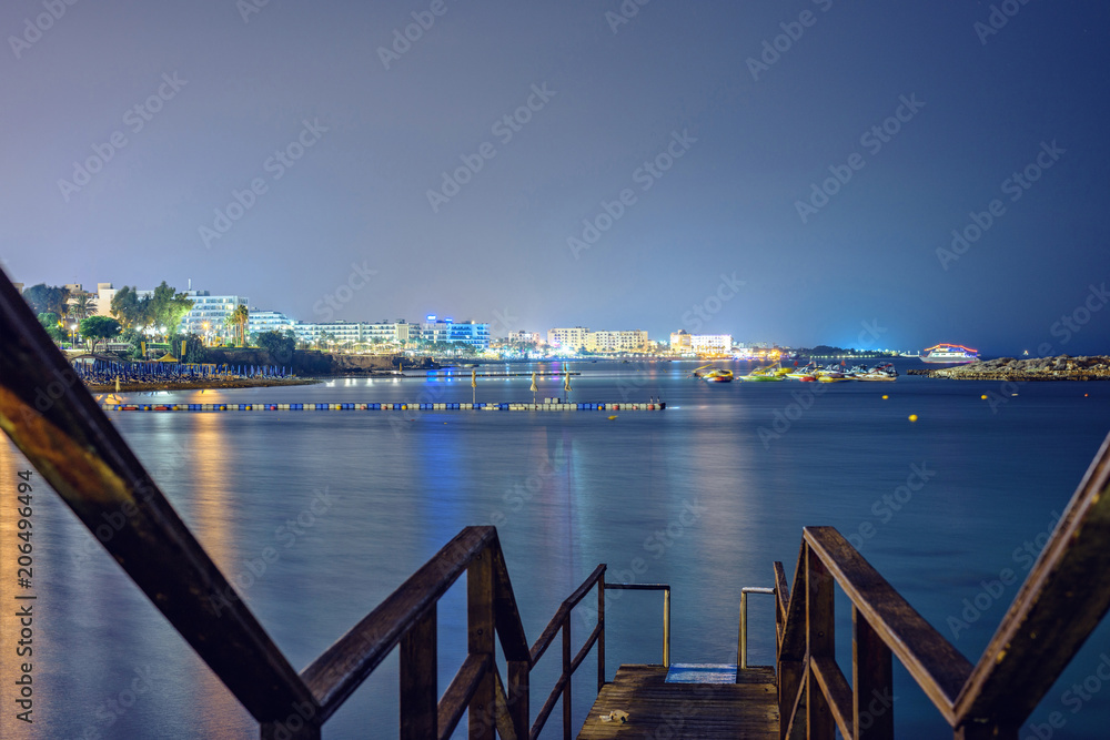 Night view from stairs to city and sea with parked boats