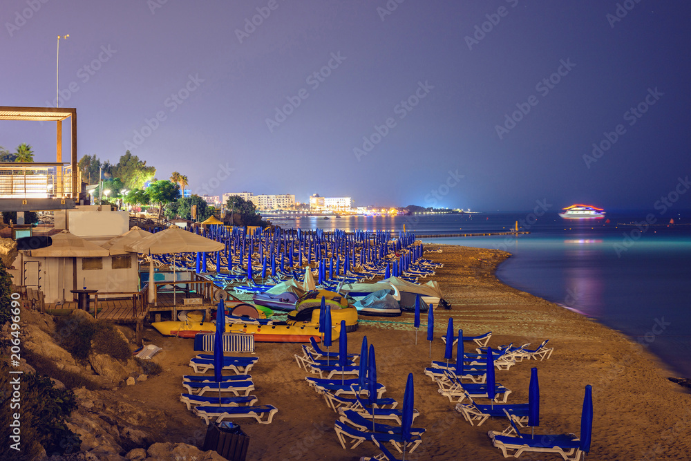 Night view to beach and city with glowing lights