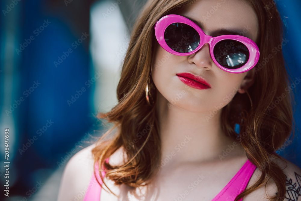 portrait of young beautiful woman in pink retro sunglasses