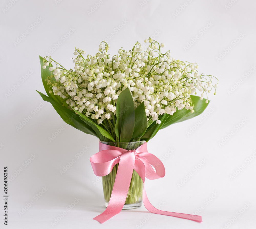 bouquet lily-of-the-valley stands on isolated background in mug with water