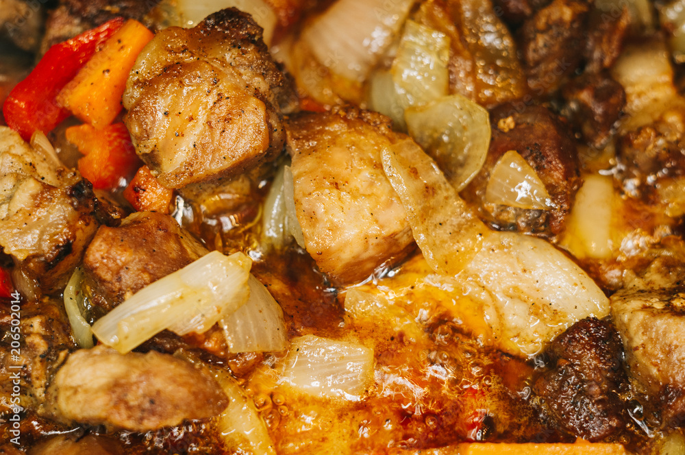 Roast meat, onions, carrots and spices, boiling in oil Roast meat, onions, carrots and spices, boiling in oil