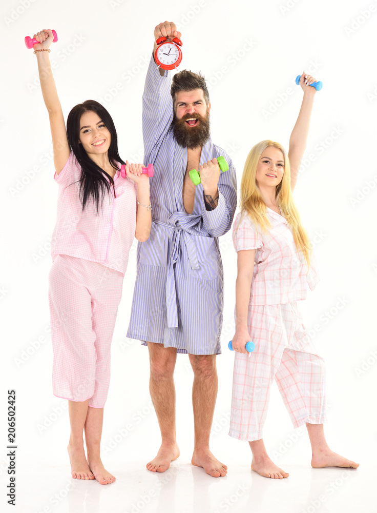 handsome man in robe, trainer holds clock, attractive young women in pajamas doing exercises with dumbbells, bodybuilder, good healthy, lifestyle, sport concept, isolated on white