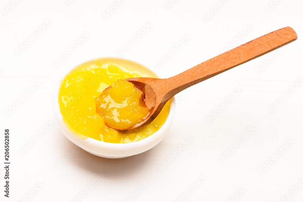 Bowl with yellow organic honey and wooden spoon. Organic food concept. Honey healthy diet sweets. Honey in little bowl on white background, close up Bowl with yellow organic honey and wooden spoon. Organic food concept. Honey healthy diet sweets. Honey in little bowl on white background, close up