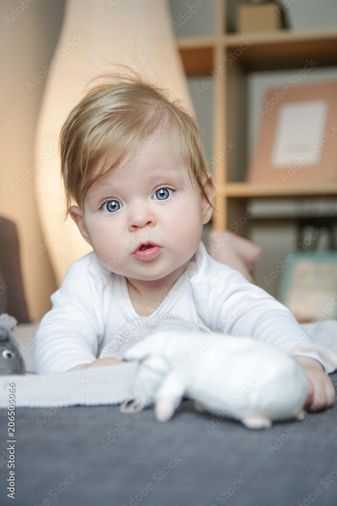 Fototapeta premium Portrait of little adorable baby on the bed playing with stuffed animal toys