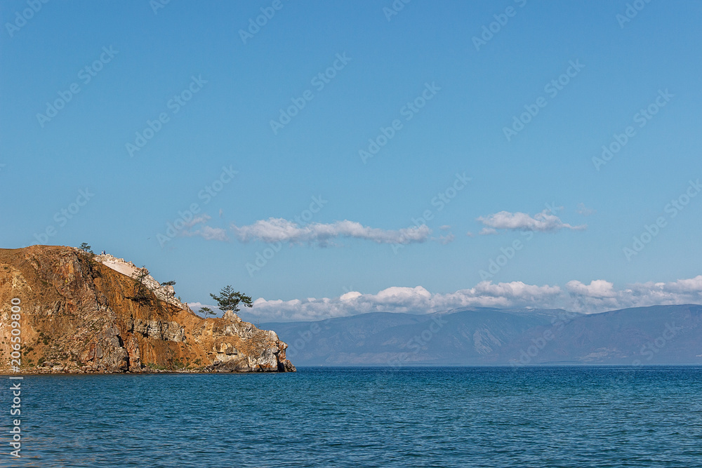 rocky coast of Lake Baikal. Pine on the cliff, concept of loneliness rocky coast of Lake Baikal. Pine on the cliff, concept of loneliness