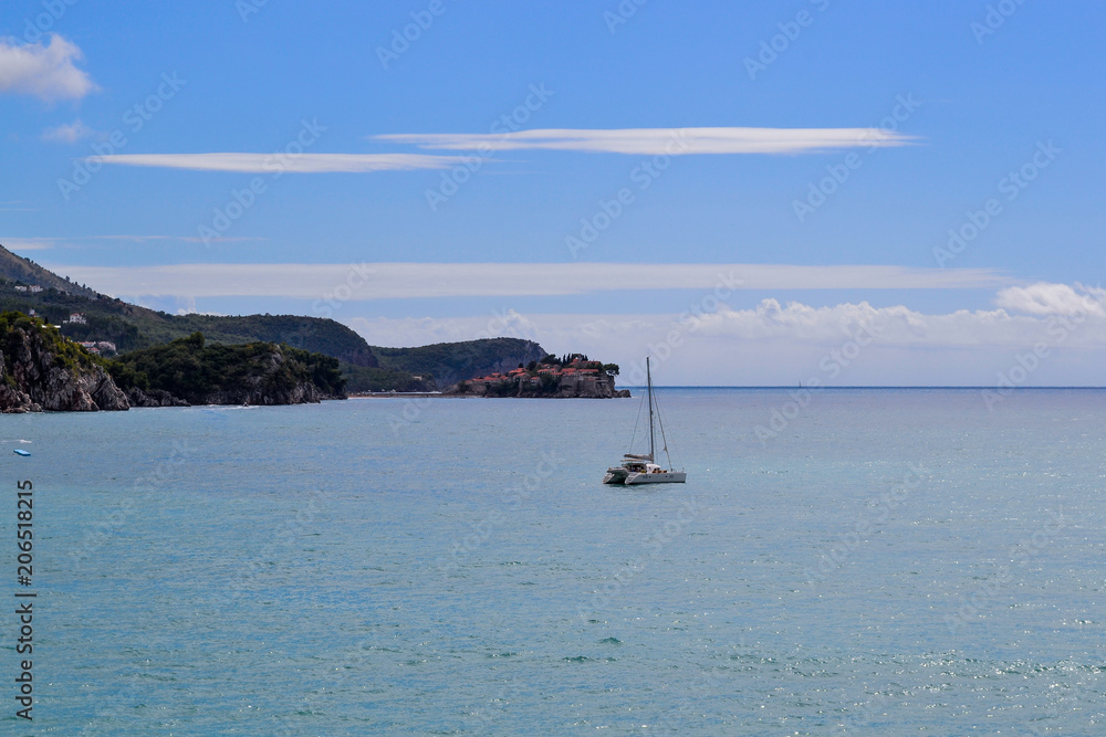 Beautiful sea bay in summer. Yacht against the background of the island of St. Stefan Adriatic Sea. Montenegro.