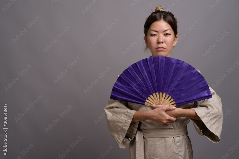 Young beautiful Kazakh woman against gray background Young beautiful Kazakh woman against gray background