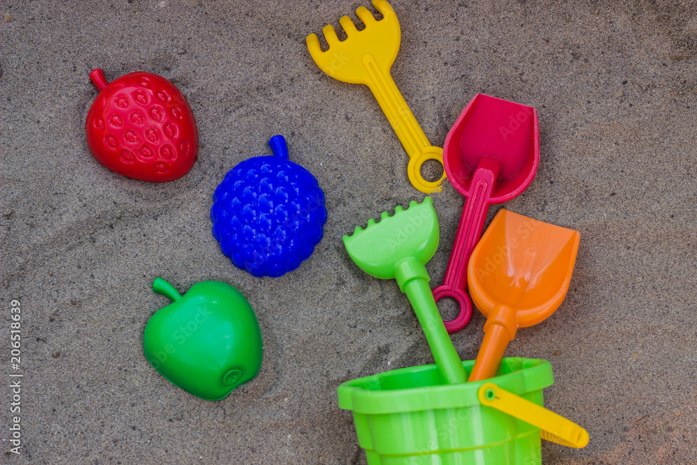 Children's beach toys - buckets, spade and shovel on sand on a sunny day Children's beach toys - buckets, spade and shovel on sand on a sunny day