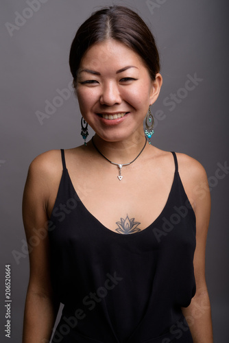 Young beautiful Kazakh woman against gray background