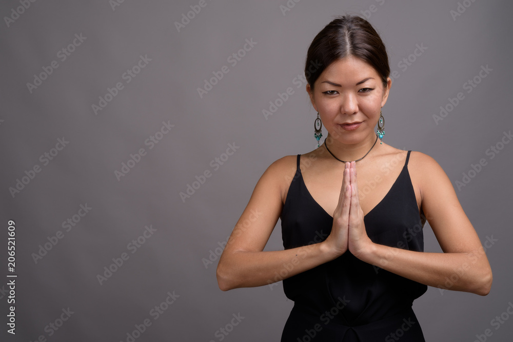 Obraz premium Young beautiful Kazakh woman against gray background