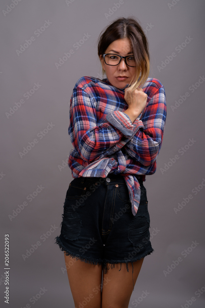 Young beautiful Kazakh woman against gray background Young beautiful Kazakh woman against gray background