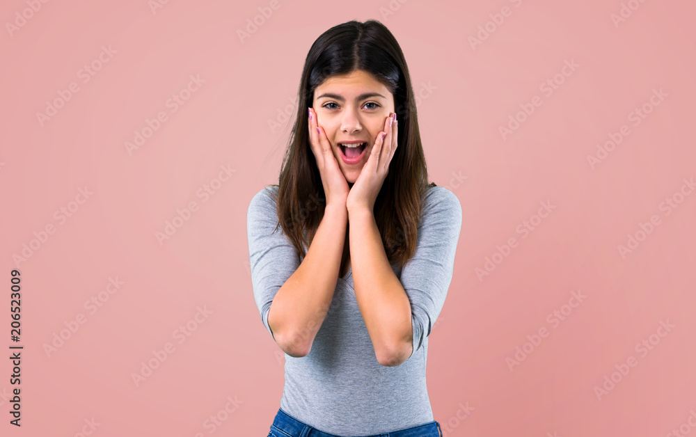 Teenager girl with surprise and shocked facial expression on pink background Teenager girl with surprise and shocked facial expression on pink background