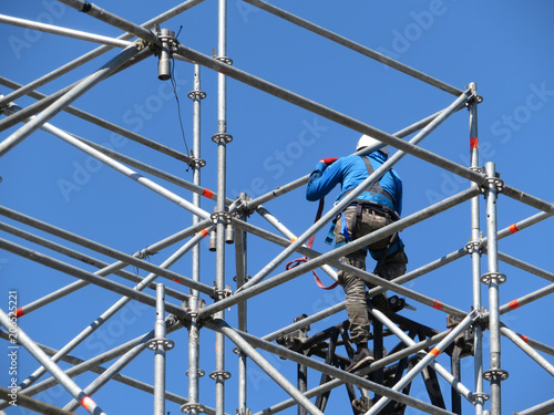 Fototapeta Construction worker working on scaffolding