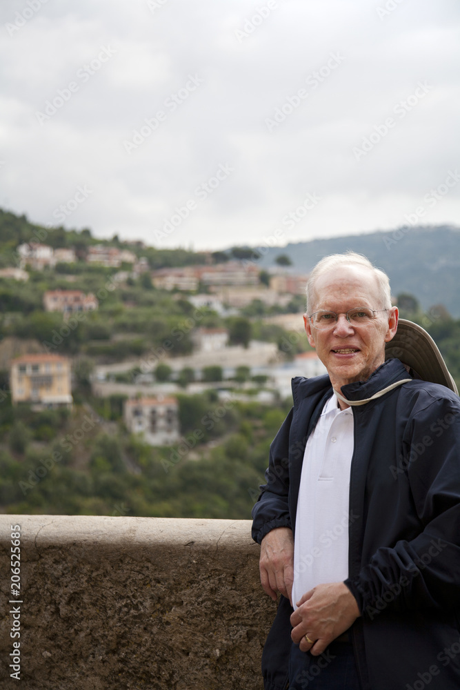 older tourist stands by a beautiful valley and hillside older tourist stands by a beautiful valley and hillside