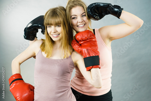 Two women friends wearing boxing gloves