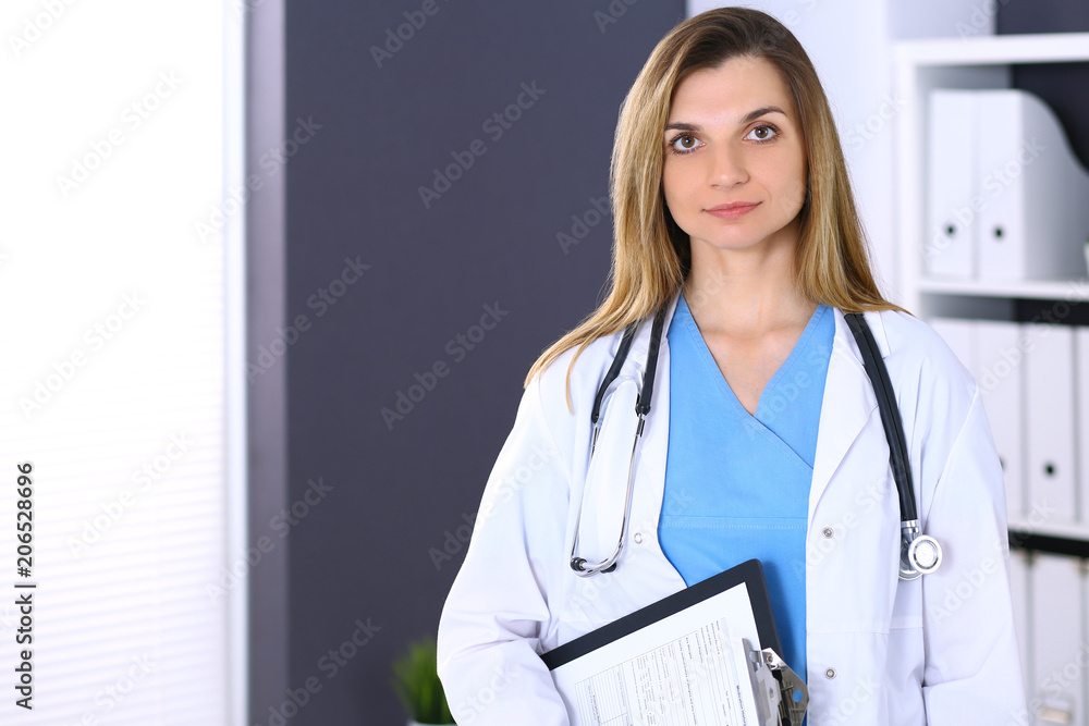 Woman doctor at work in hospital office. Portrait of female physician. Medicine and health care concept Woman doctor at work in hospital office. Portrait of female physician. Medicine and health care concept