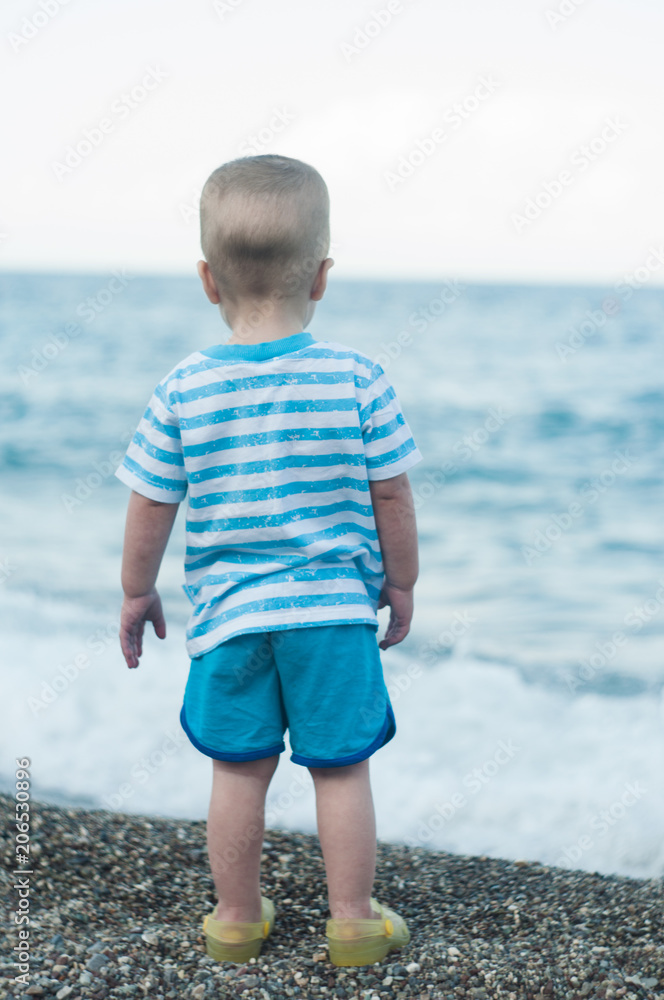 Small boy looking in the sea Small boy looking in the sea