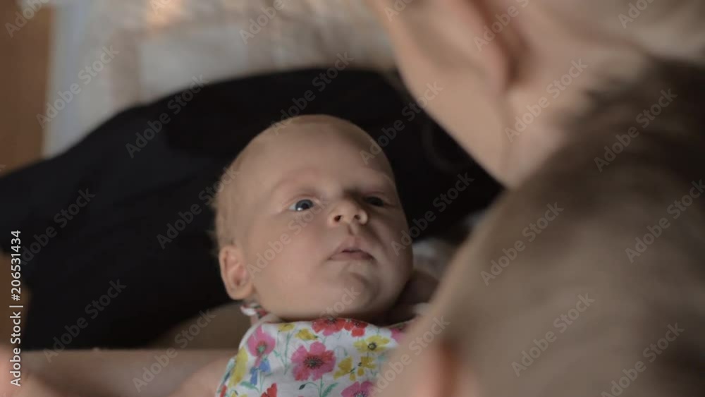 Mother and elder son looking at two months baby girl and talking to her. Little beloved daughter and sister Mother and elder son looking at two months baby girl and talking to her. Little beloved daughter and sister