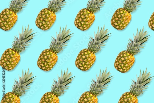Colorful fruit pattern, Pineapples on a pastel blue background. Top view.