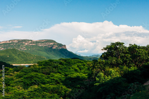 the beauty of nature, mountains covered with lush vegetation, under a sky of white clouds