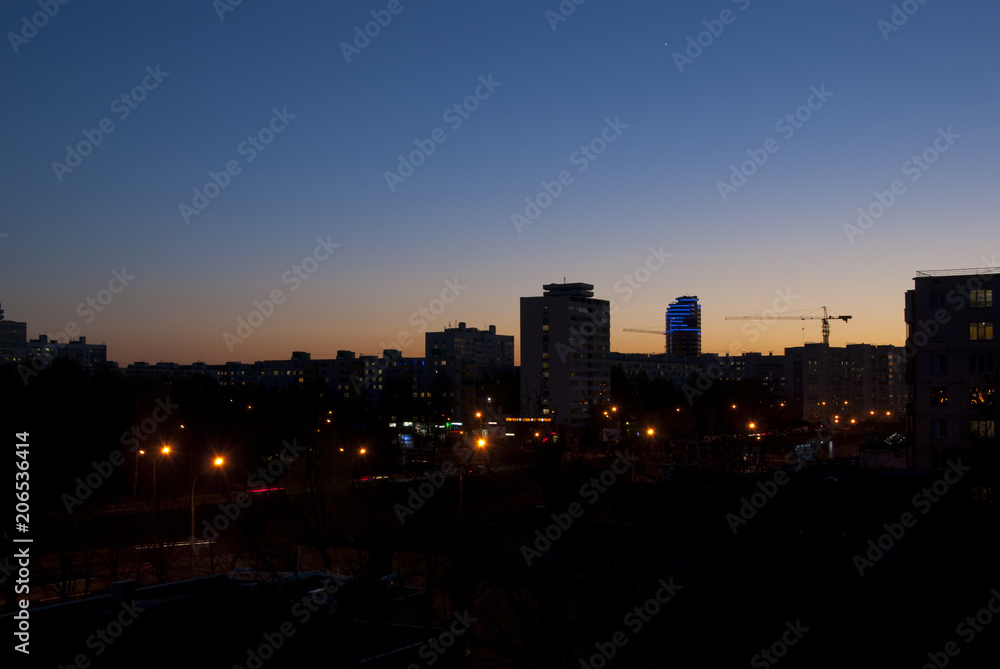 Evening sky over the city with streets and high houses