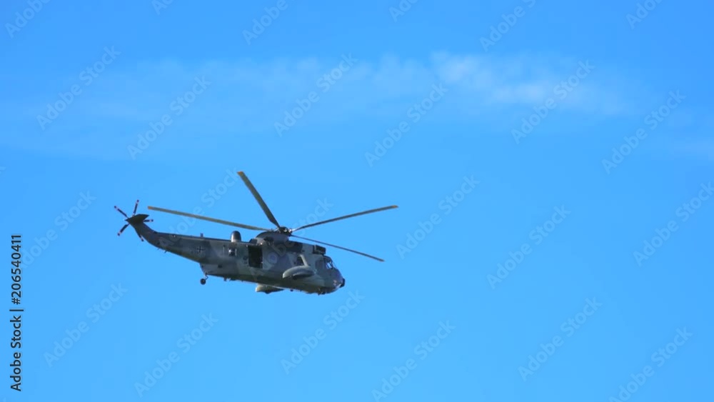 Military helicopter flying against blue sky. 4K. Military helicopter flying against blue sky. 4K.