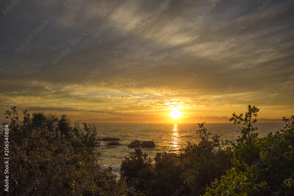 Dramatic golden sunrise over Boulders Beach, Simonstown, Cape Town, South Africa.