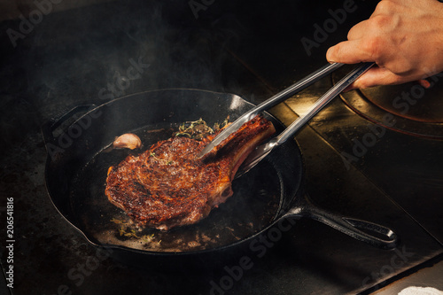 Cooking steak in a cast iron pan.