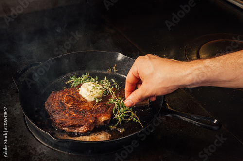 Cooking steak in a cast iron pan.