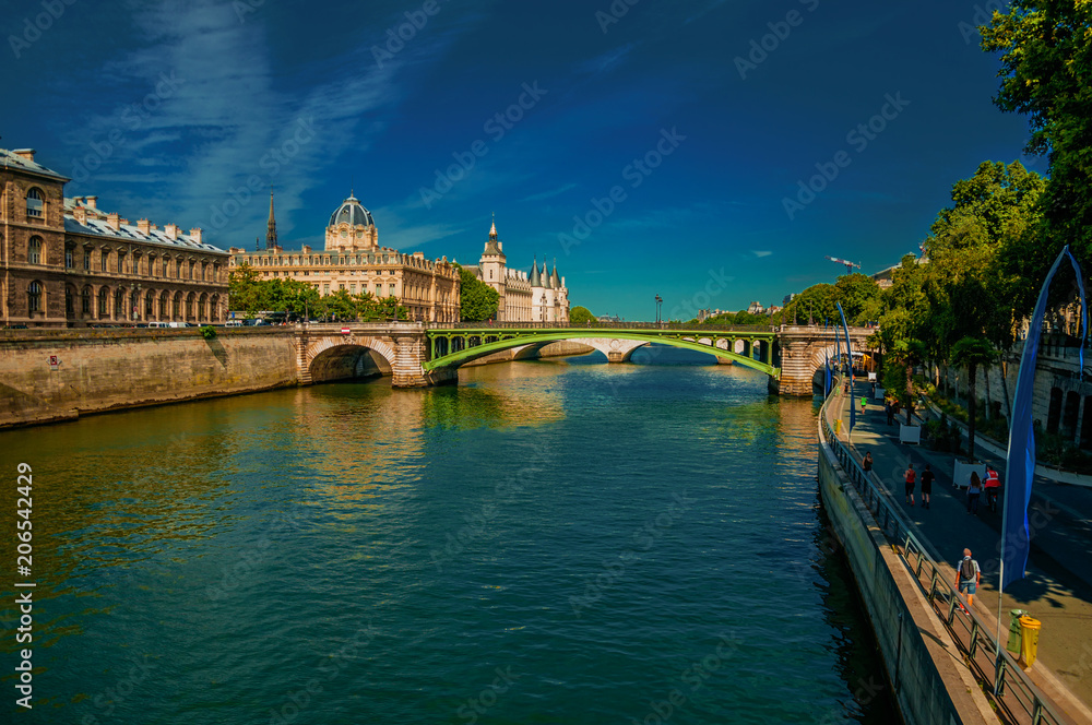 Bridge on the Seine River and the Conciergerie building with blue sky at Paris. Known as the “City of Light”, is one of the most impressive world’s cultural center. Northern France. Retouched photo.
