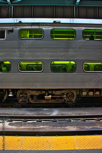 Train sitting on tracks seen from platform in train station.