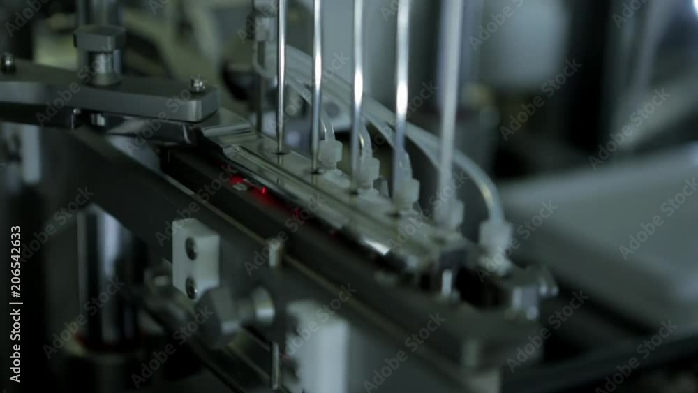 Robotic manipulator arms with a containers filled with blood in a modern atomated laboratory.Pharmaceutical production plant.Medical research process. Hellthcare and medicine concept. Robotic manipulator arms with a containers filled with blood in a modern atomated laboratory.Pharmaceutical production plant.Medical research process. Hellthcare and medicine concept.