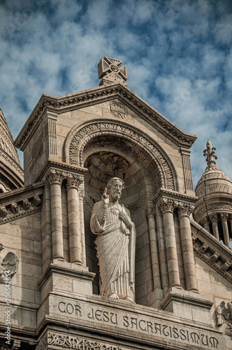 Religious stone statue detail and decoration at the Basilica of Sacre Coeur facade in Paris. Known as the “City of Light”, is one of the most impressive world’s cultural center. Northern France.