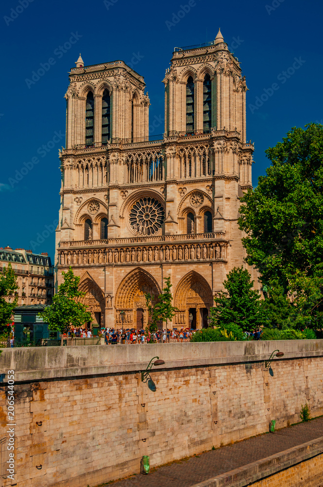 People, tree-lined Seine River and gothic Notre-Dame Cathedral at Paris. Known as the “City of Light”, is one of the most impressive world’s cultural center. Northern France. Retouched photo