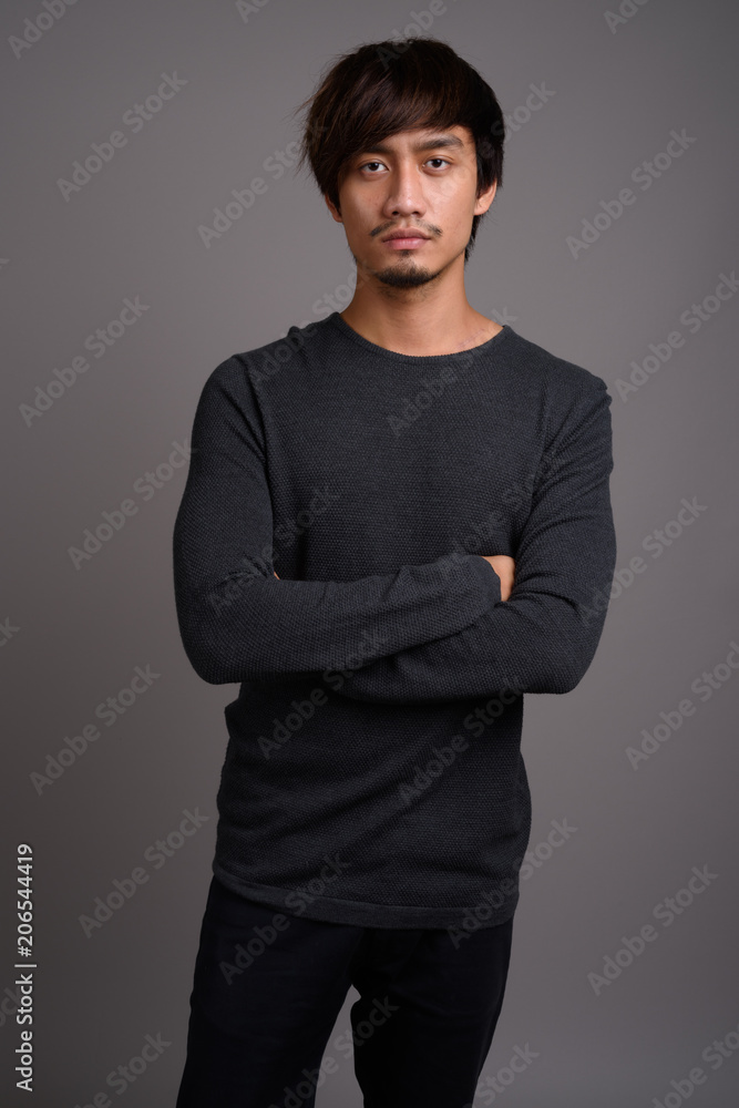 Young Asian man against gray background Young Asian man against gray background