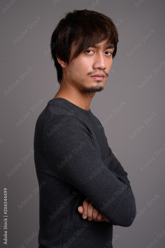 Young Asian man against gray background Young Asian man against gray background