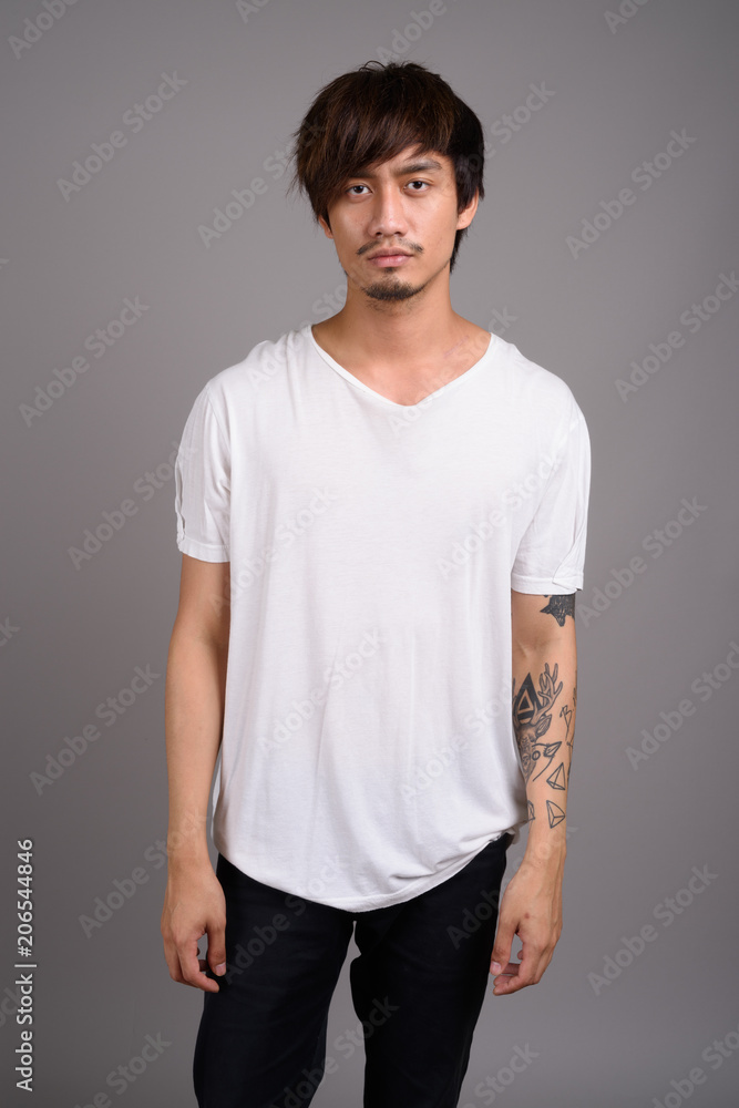 Young Asian man against gray background Young Asian man against gray background