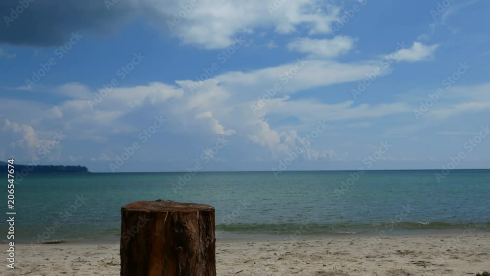cutting log stand on beach like a table for put something on , Background are beautiful sand beach with soft wave in sea water , cloudy blue sky sunny day cutting log stand on beach like a table for put something on , Background are beautiful sand beach with soft wave in sea water , cloudy blue sky sunny day