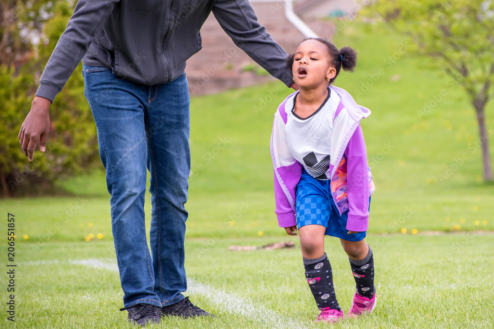 A young girl is learning how to play soccer	
